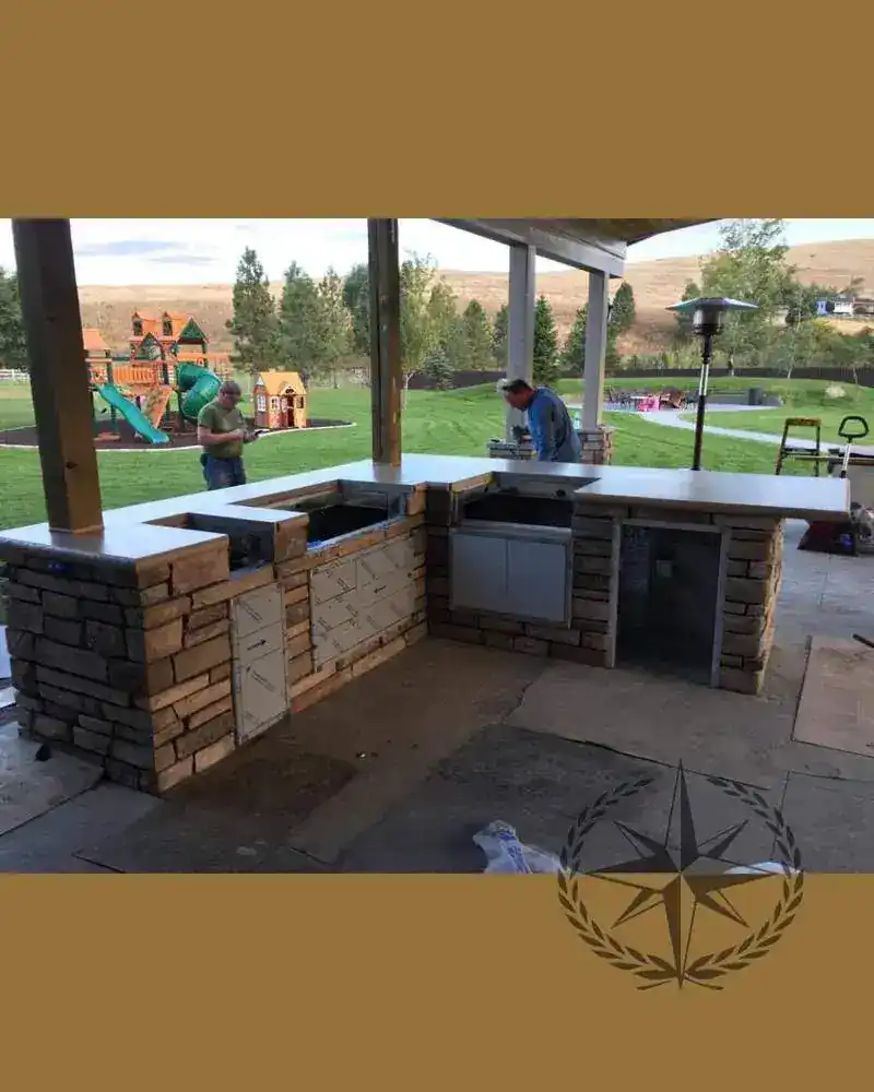 The outdoor kitchen taking shape on its stone base, looking out to the lawn