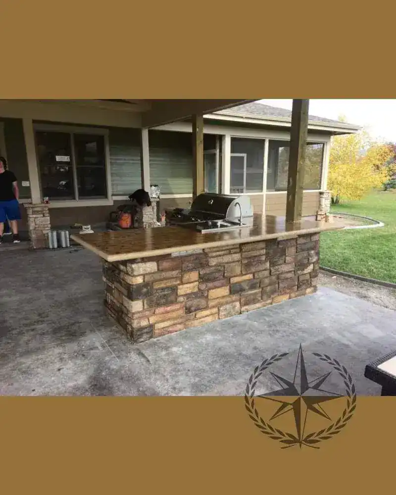The finished outdoor kitchen and bar with stone surround and stainless appliances