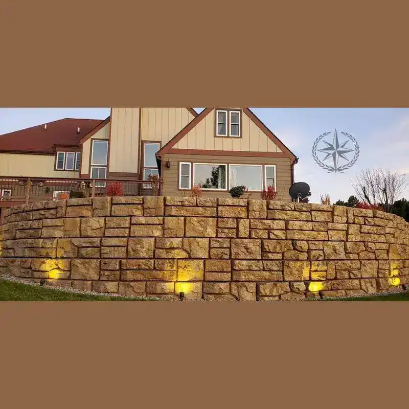 The boulder retaining walls lit at dusk, with the house above