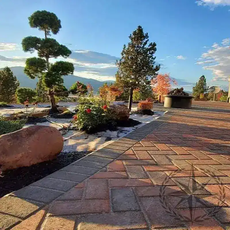 Boulder planting beds and paver paths through the garden