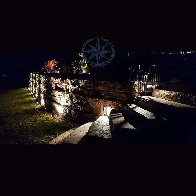 Landscape lighting washing the retaining wall after dark