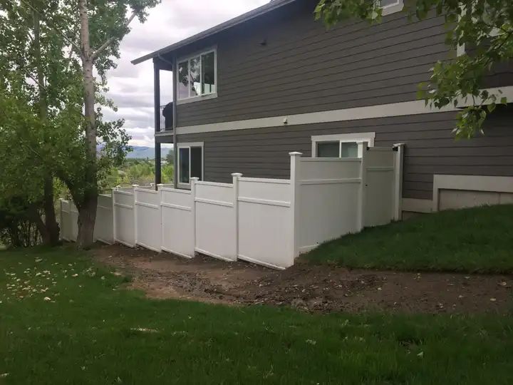 The finished vinyl fence from the lawn, the house behind