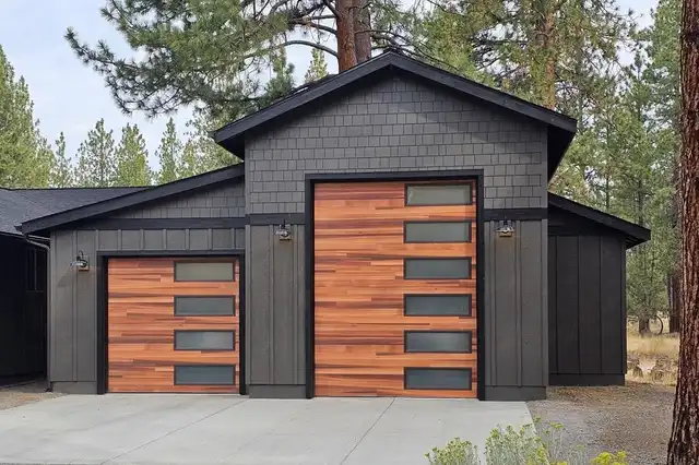 Garage with a wood-tone overhead door and black board-and-batten