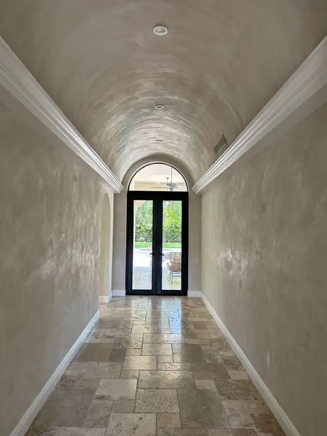 Plastered hallway to an arched door